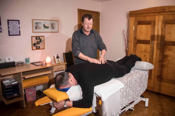 Pat Naegeli durant une séance de magnétisme avec une personne allongée sur une table de massage.